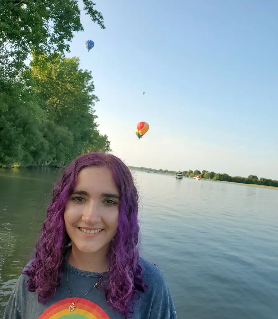 Alice avec des montgolfières en arrière-plan près de la rivière Richelieu