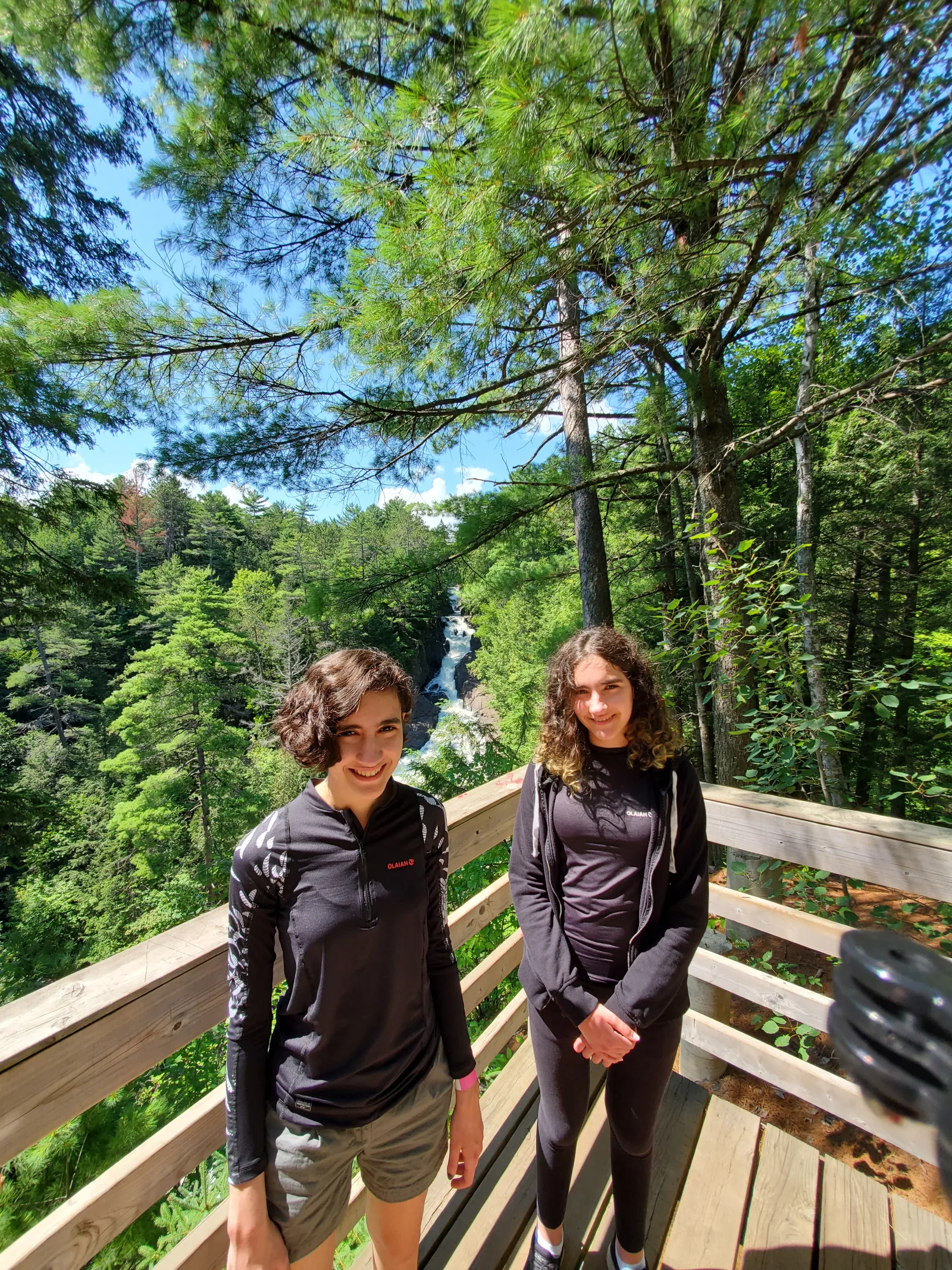 Dos adolescentes en un mirador con una cascada de Sainte-Ursule al fondo