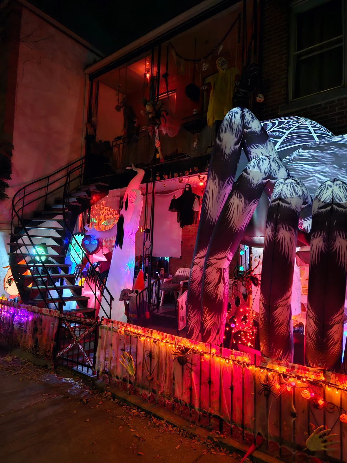 Casa decorada para Halloween en Montreal, con araña inflable gigante, fantasmas y luces en la escalera