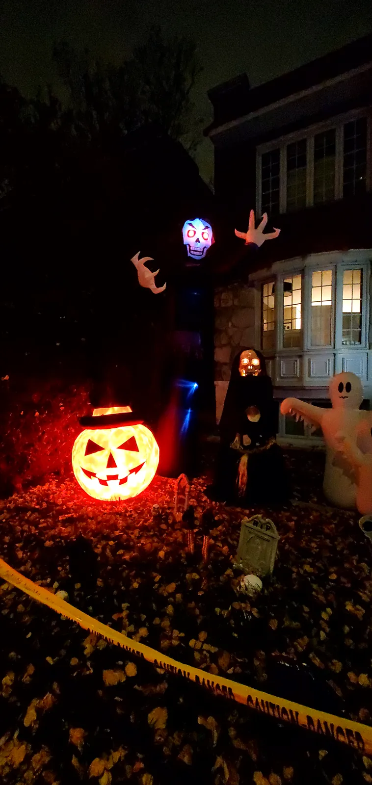 Jardín decorado para Halloween en Montreal, con calabaza iluminada, lápidas y fantasmas